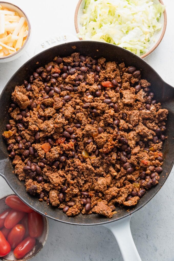 Finished ground beef and bean taco filling, cooked in a small cast iron skillet.
