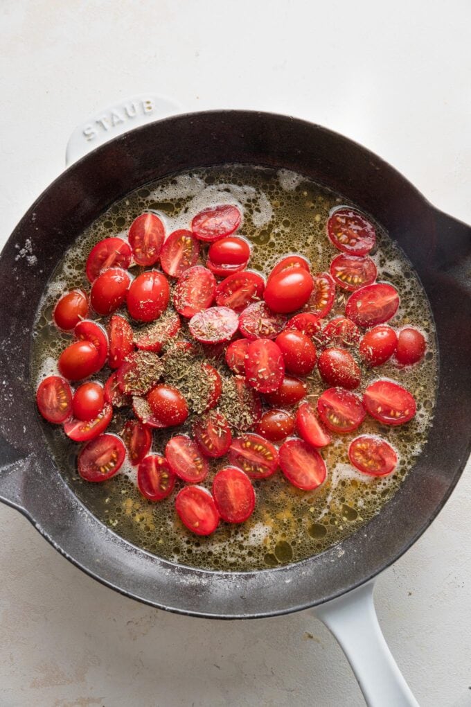 Cherry tomatoes cut in half and stirred into simmering broth with butter and garlic.