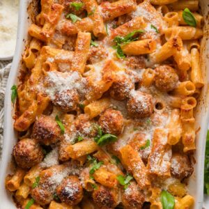 Large casserole dish full of baked rigatoni and meatballs.