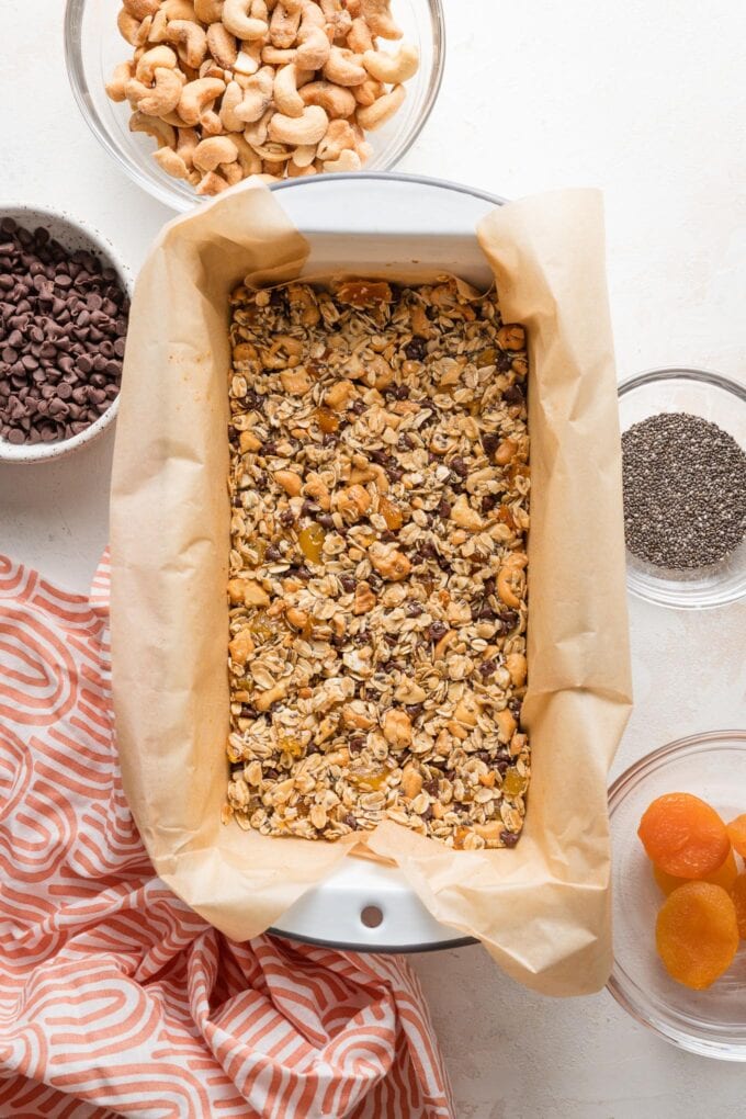 Loaf pan lined with parchment paper and filled with a batch of homemade snack bars.