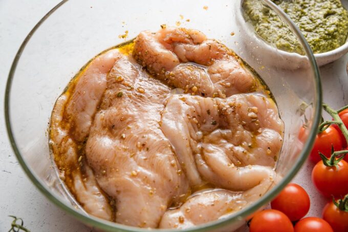 Chicken breasts marinating in a simple mix of olive oil, balsamic vinegar, garlic, and spices.