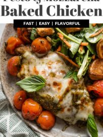 Pesto Baked Mozzarella Tomato Chicken is one ultra-flavorful dinner that largely bakes itself! It's got juicy, pan-seared chicken breasts smothered with pesto, topped with gooey mozzarella, and roasted alongside sweet cherry tomatoes. The result is a simple, flavorful dinner that comes together in one pan with everyday ingredients!