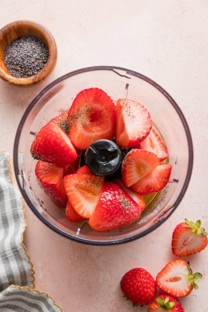 Strawberries, apple cider vinegar, extra-virgin olive oil, salt, and pepper, in a miniature food processor ready to blend.