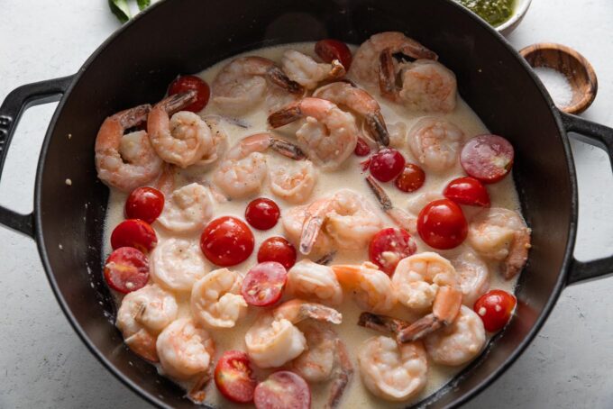Cream sauce around shrimp and tomatoes.