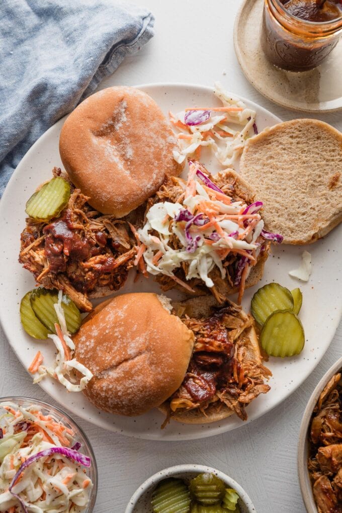 Countertop set with platter of pulled BBQ pork sandwiches.