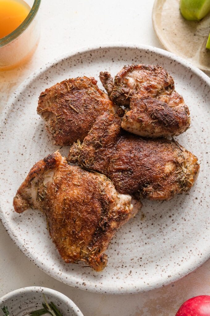 Seared chicken thighs removed to a plate to rest.