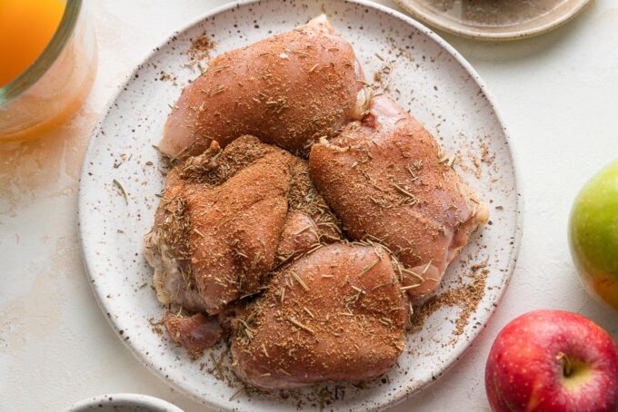 Chicken thighs seasoned with a spice rub of coriander, rosemary, thyme, cinnamon, nutmeg, salt, and pepper.