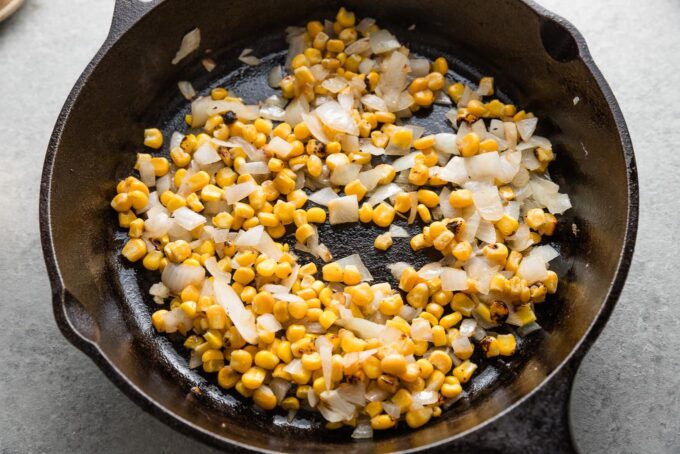 Onion and corn in a cast iron skillet.