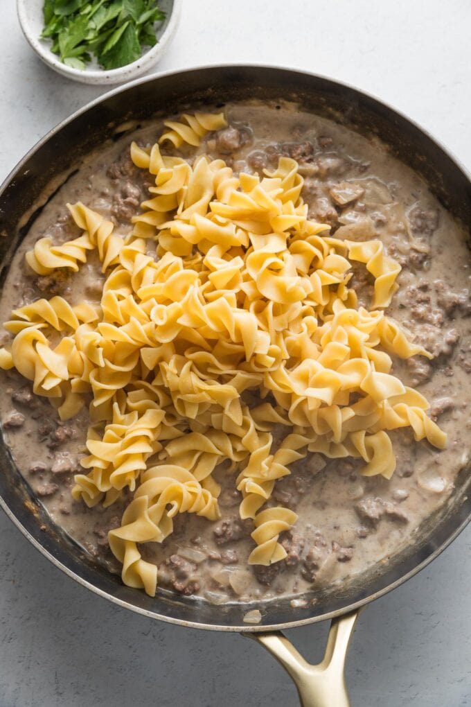 Egg noodles added to meat sauce.