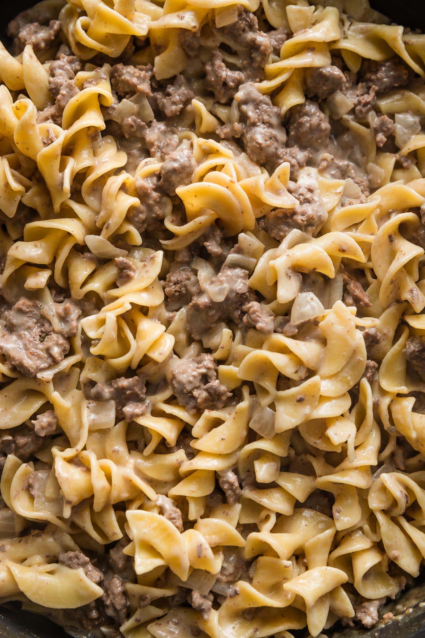 Close up of ground beef and noodles in a simple homemade cream sauce, just finished in a large skillet.