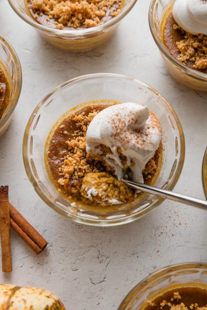Small spoon lifting a spoonful of creamy pumpkin custard.