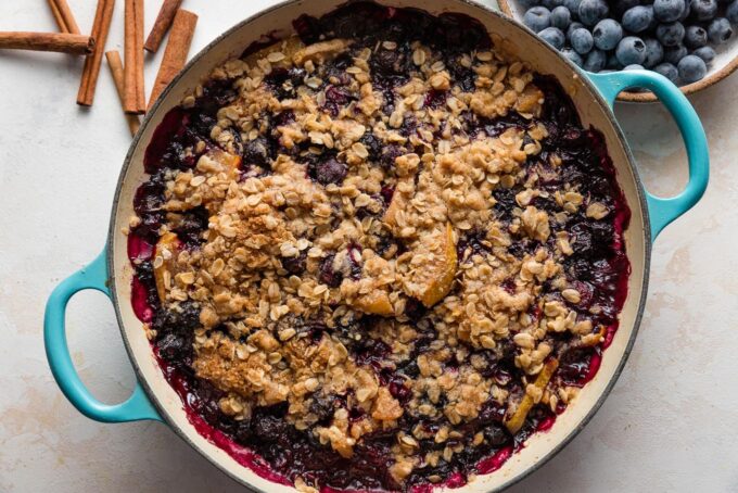 Just-baked pear and blueberry crisp pulled out of the oven and cooling on the counter.