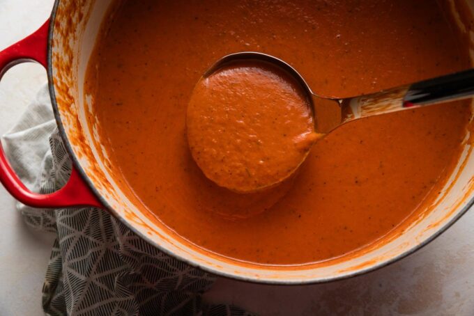 Ladle full of velvety tomato butternut bisque.