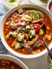 Close up of a spoon in a bowl of chipotle chicken tortilla soup.