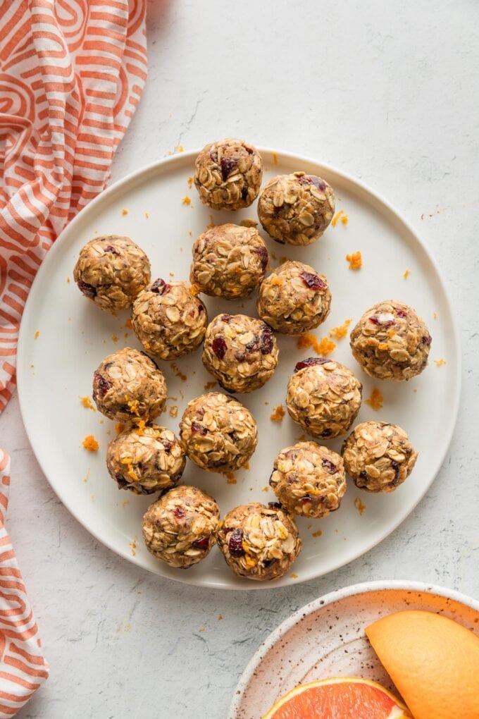 Overhead view of a plate of cranberry orange flavored protein balls sitting on a kitchen counter.
