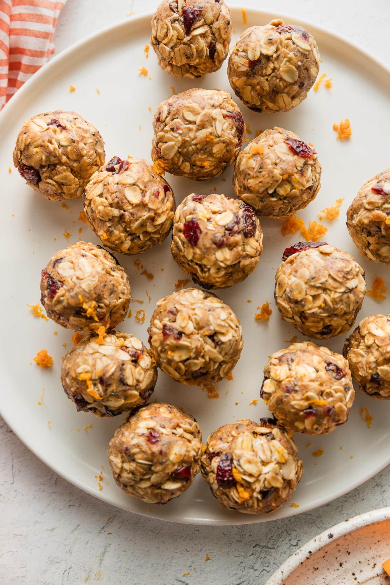 Small plate full of small protein bites flavored with dried cranberries, orange, maple syrup, and cinnamon.