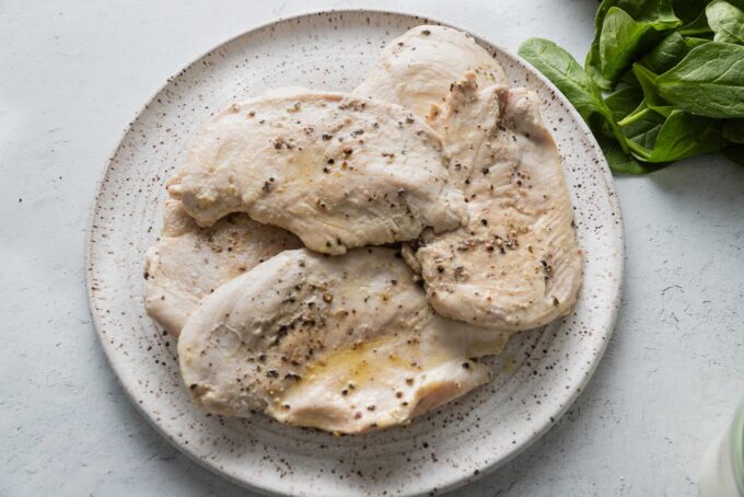 Chicken breasts lightly browned and resting on a plate.