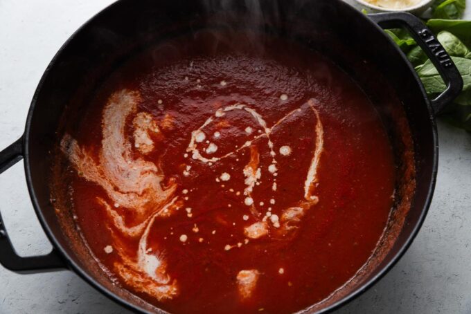 Cream just poured into homemade tomato sauce.
