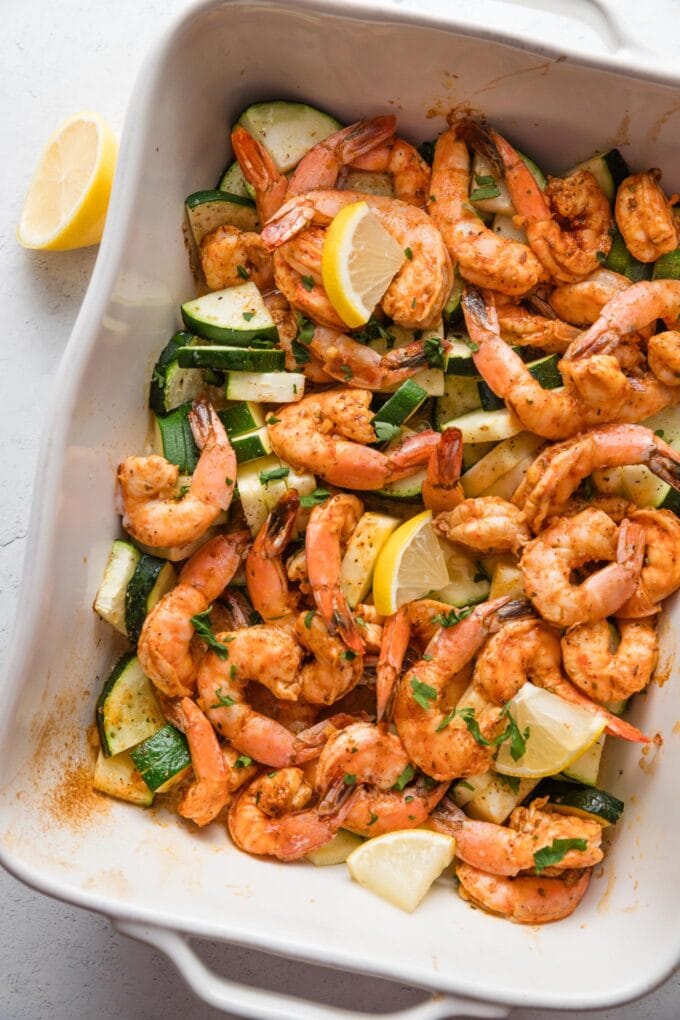 Baking dish full of shrimp and zucchini.