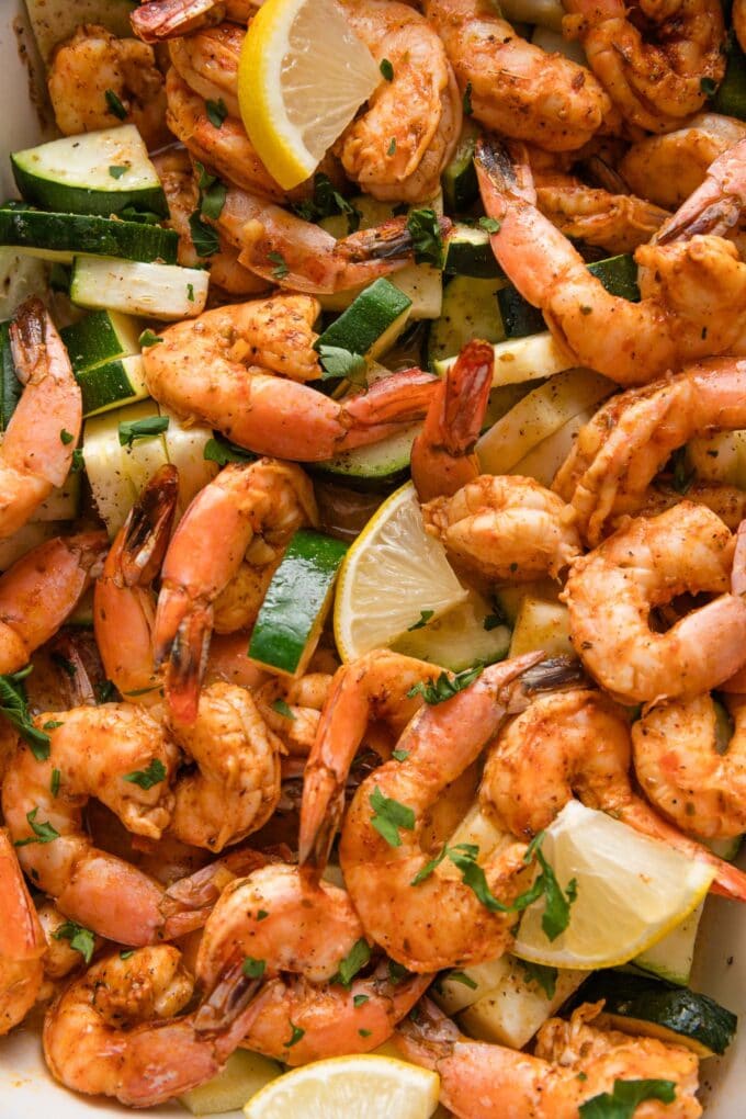 Close up of shrimp and zucchini roasted with seasonings in the oven.
