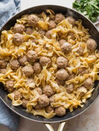 Large skillet full of quick Swedish meatballs with sauce and egg noodles.