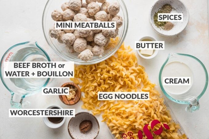 Labeled overhead image of frozen mini beef meatballs, egg noodles, water and beef bouillon paste, cream, Worcestershire sauce, garlic, and spices.