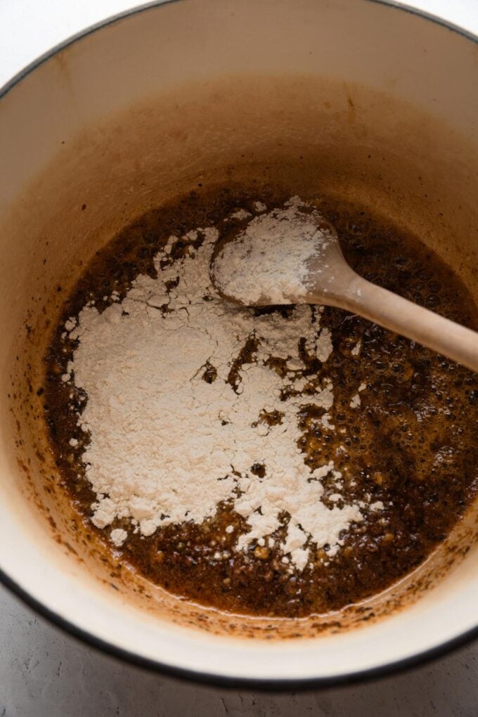 Flour sprinkled on top of melted butter with sun dried tomato pesto and other aromatics in a large pot.