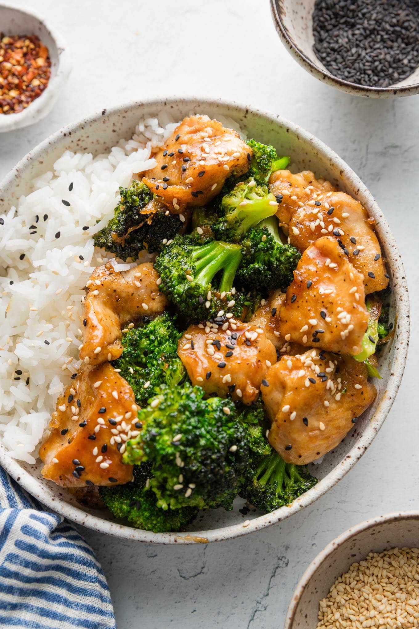 Bowl of Asian chicken and broccoli with rice and sesame seeds.