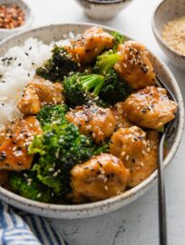 Angled view of homemade Asian chicken and broccoli served over white rice.