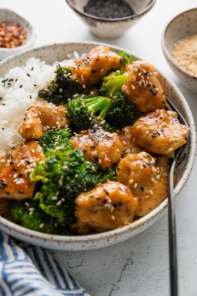Angled view of homemade Asian chicken and broccoli served over white rice.