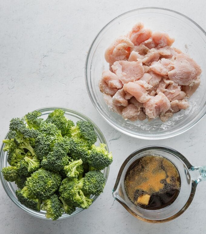 Flat lay photo of chicken breast bites dusted with cornstarch, kosher salt, and black pepper; broccoli florets; and a quick honey-soy-ginger-garlic stir fry sauce.