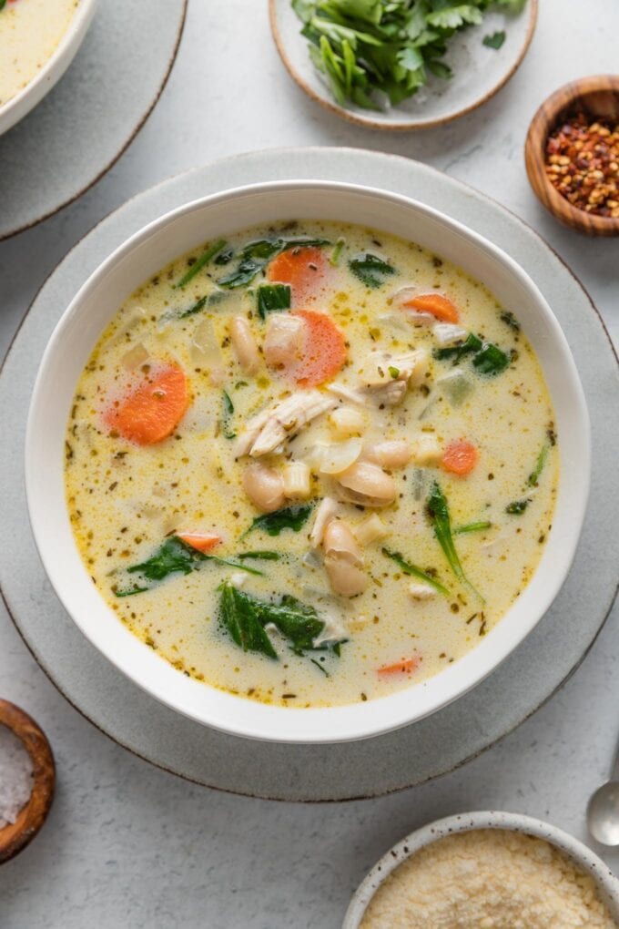 Bowl of chicken soup on a small plate.
