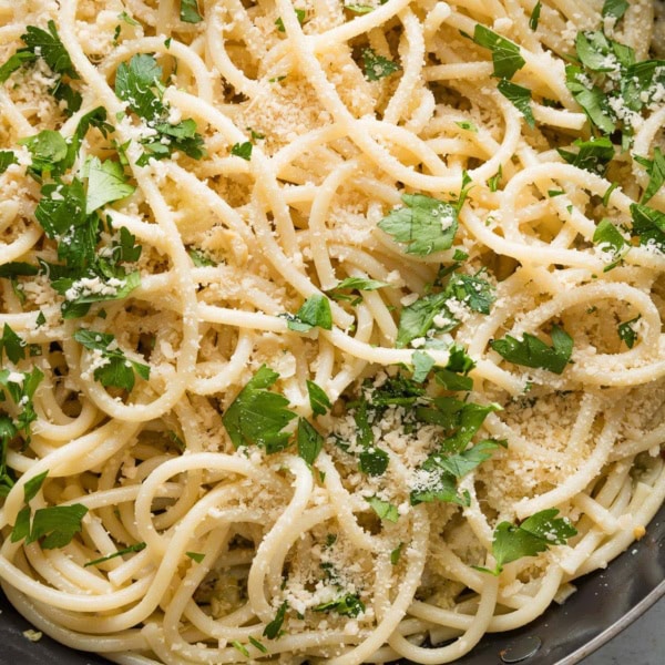 Close up of spaghetti aglio e olio in a large skillet.