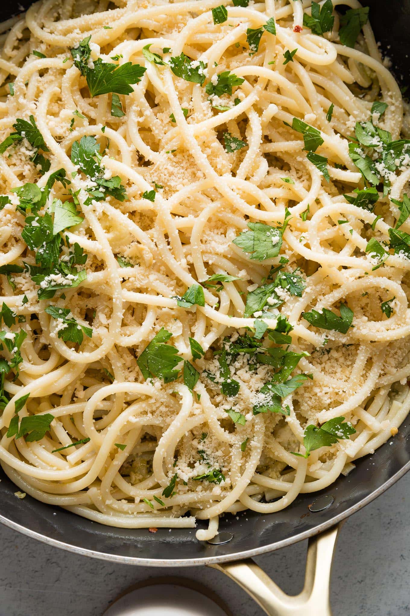 Close up of spaghetti aglio e olio in a large skillet.
