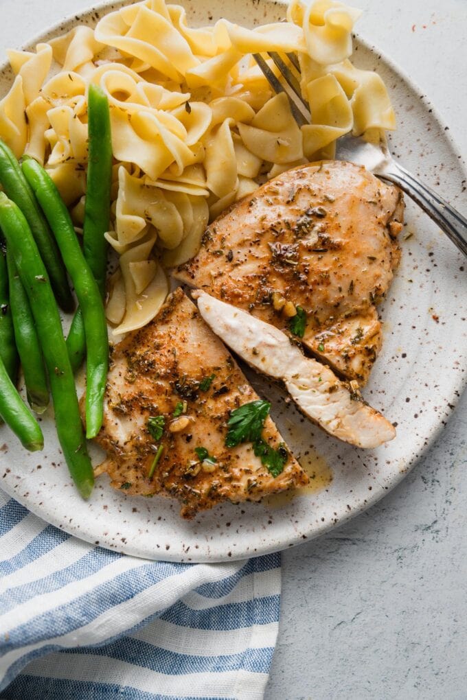 Close up of a garlic butter chicken breast sliced open to show the tender, juicy, interior.