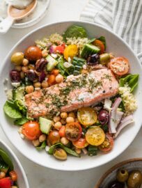 Bowl with couscous, Greek baked salmon, and a big chickpea vegetable salad.