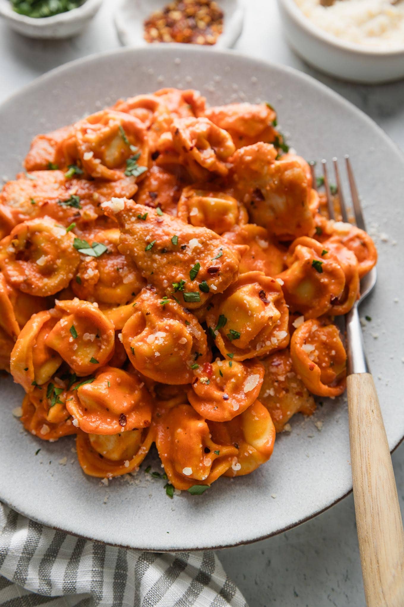 Plate filled bites of chicken and cheese-filled tortellini simmered in a light homemade tomato cream sauce infused with Italian herbs.