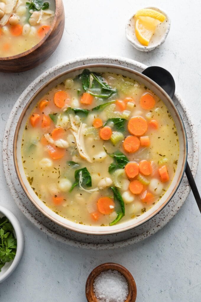 Bowl of brothy white bean chicken gnocchi soup.