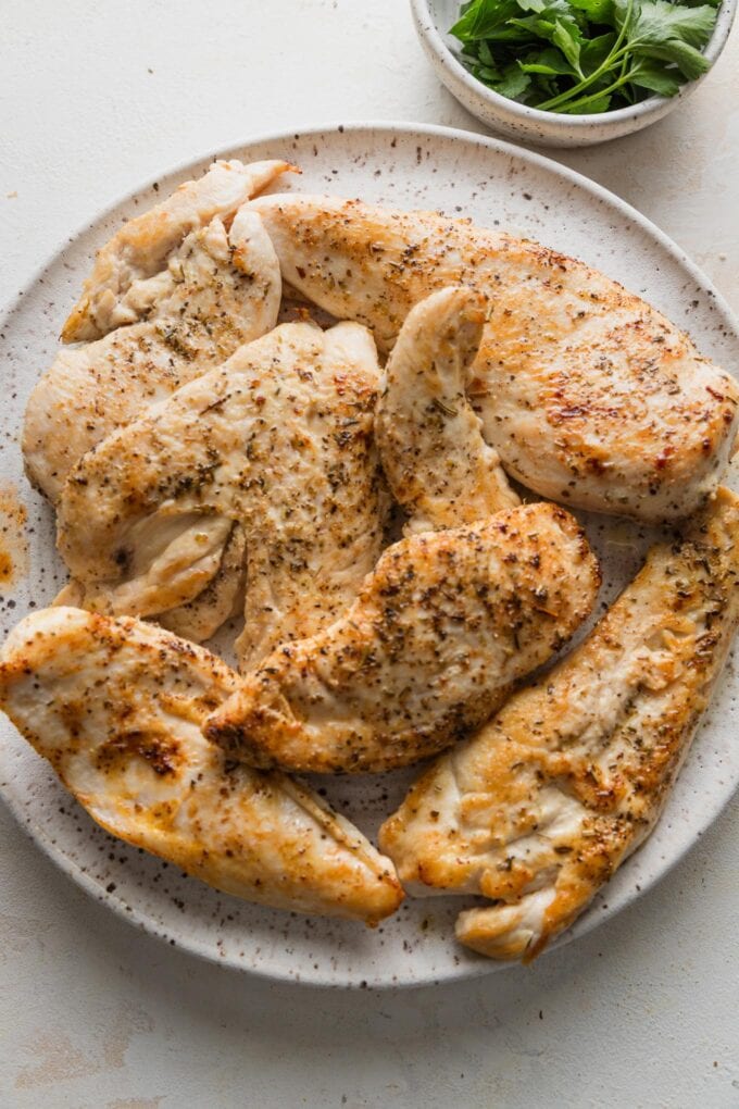 Pan-seared chicken breasts resting on a plate.