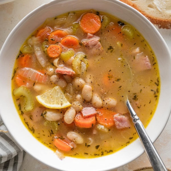 Bowl of ham and white bean soup with lots of carrots and other veggies.