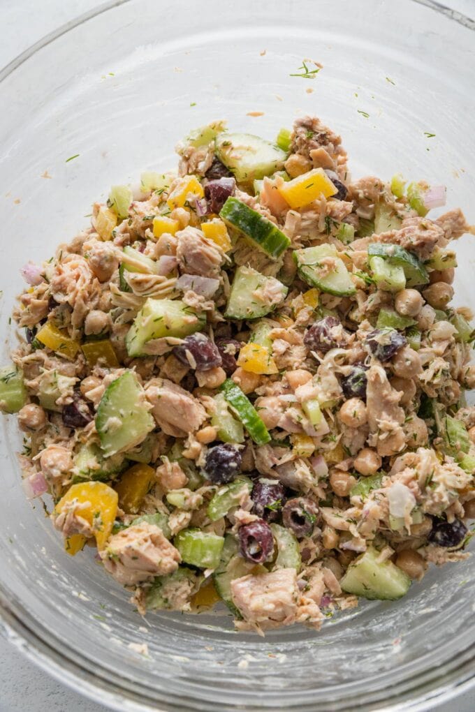 Mediterranean tuna salad with dill, olives, chickpeas, and a red wine vinegar Greek yogurt dressing, all in a large glass prep bowl.