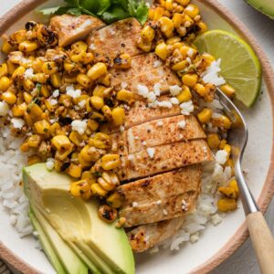 Street corn chicken and rice bowl with avocado, cilantro, and lime.