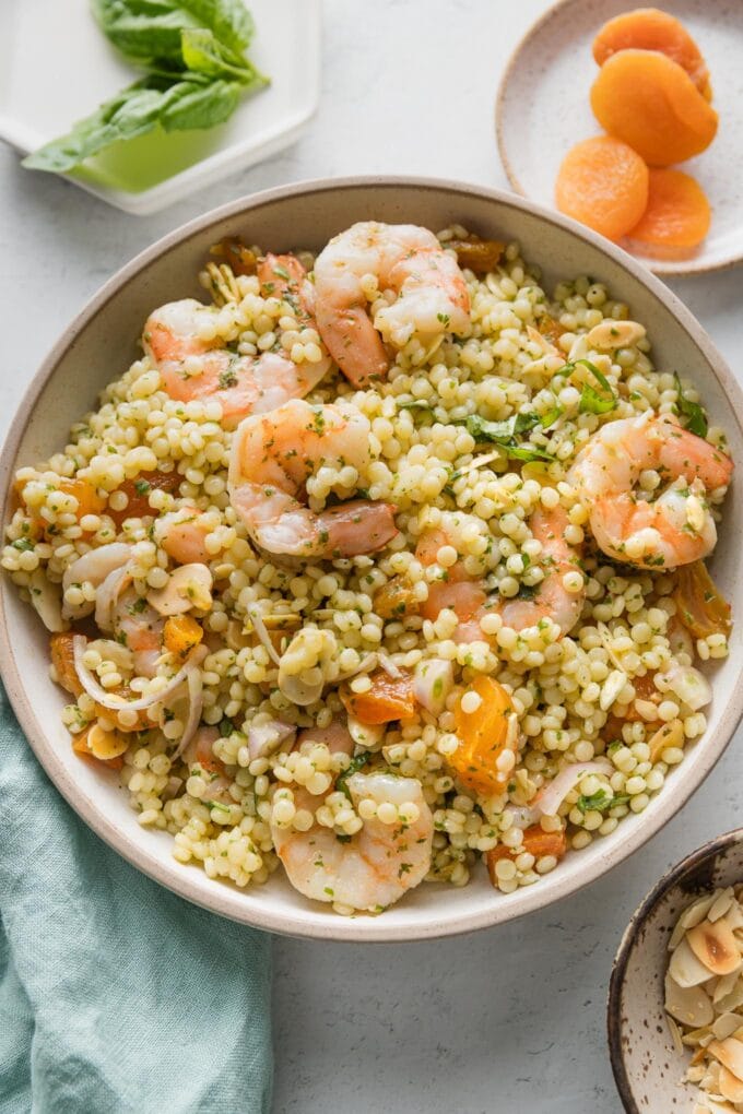 Lunch salad with poached shrimp, pearl couscous, fresh basil and basil dressing, slivered almonds, dried apricots, and shallots.