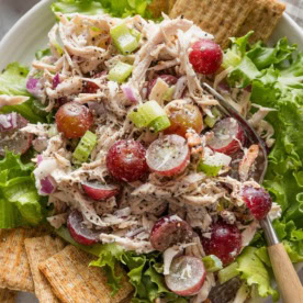 Whole Foods copycat Sonoma chicken salad plated over green leaf lettuce with Triscuits on the side.