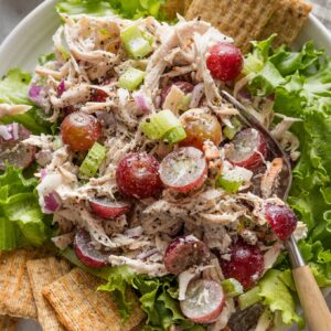 Whole Foods copycat Sonoma chicken salad plated over green leaf lettuce with Triscuits on the side.