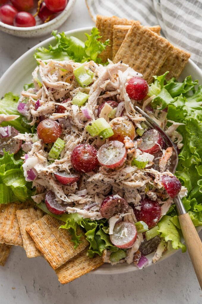 Whole Foods copycat Sonoma chicken salad plated over green leaf lettuce with Triscuits on the side.