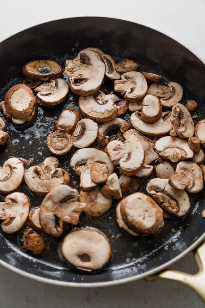 Mushrooms added to a skillet to fry in bacon grease.