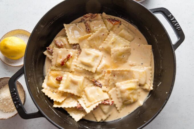 Store-bought ravioli simmering directly in a quick homemade cream sauce.