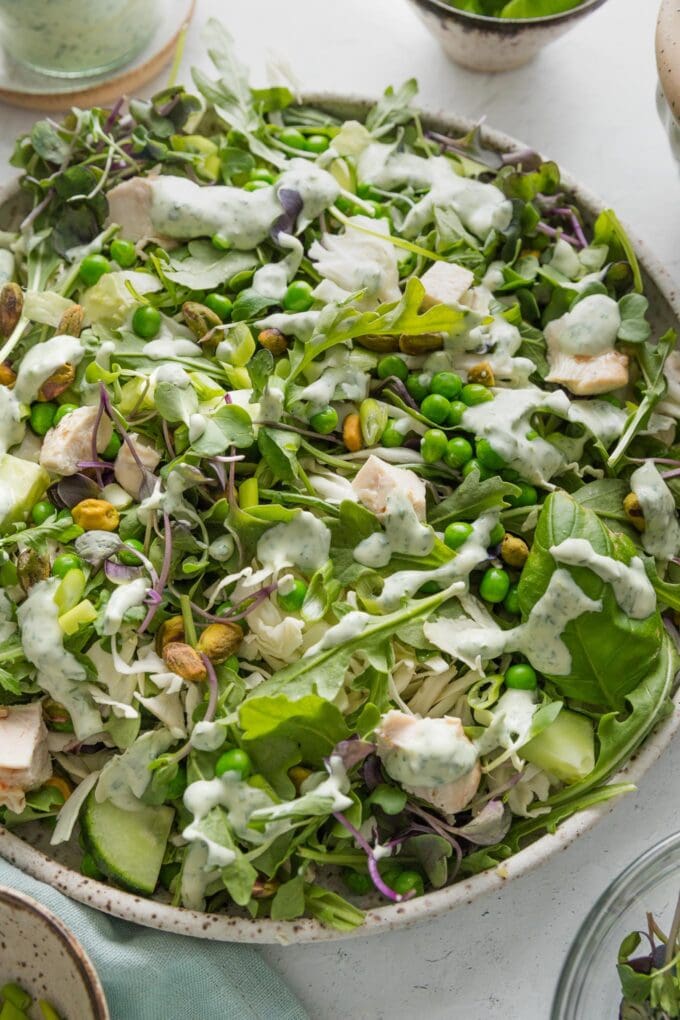 Green goddess salad in a large speckled ceramic bowl.