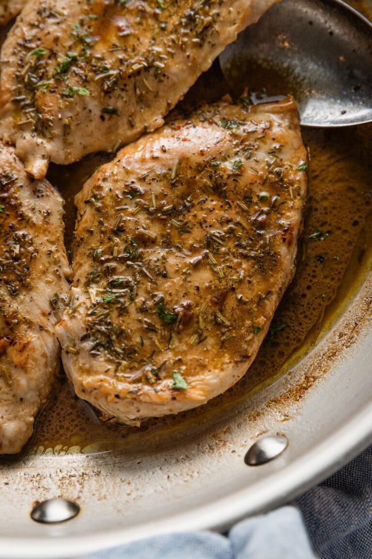 Chicken breast in a skillet with an herb and balsamic pan sauce.